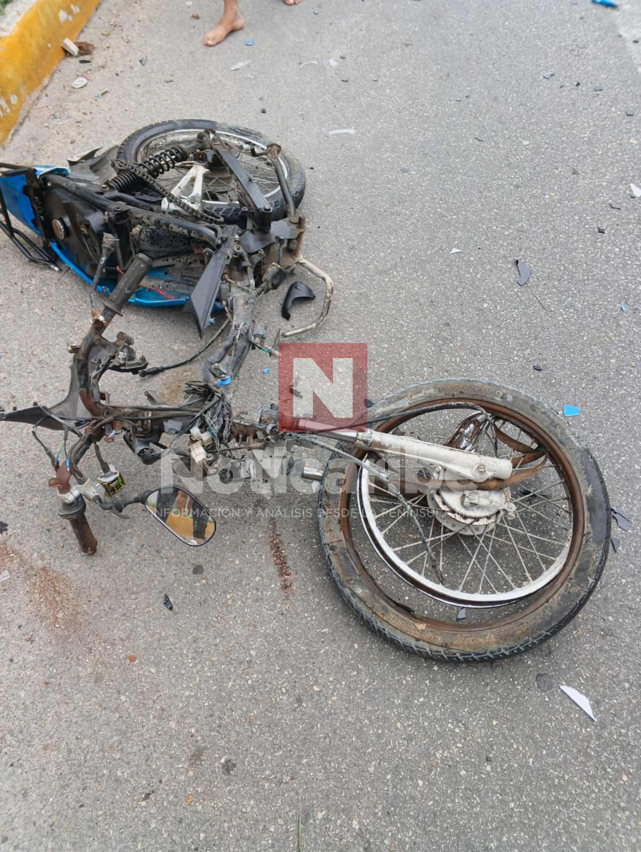 Motocicleta severamente dañada sobre el pavimento después del choque en Villas del Sol
