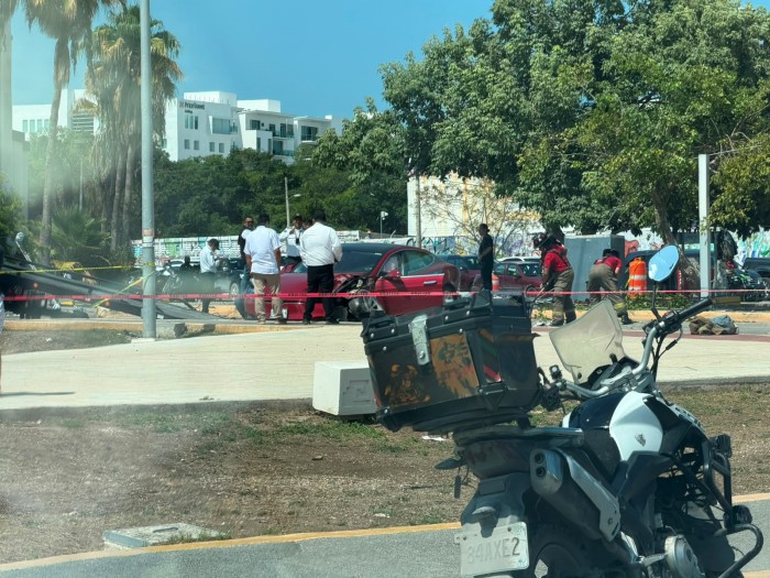 Tesla rojo destrozado junto a postes y cables caídos en el cruce de Kabah y Las Torres de Cancún